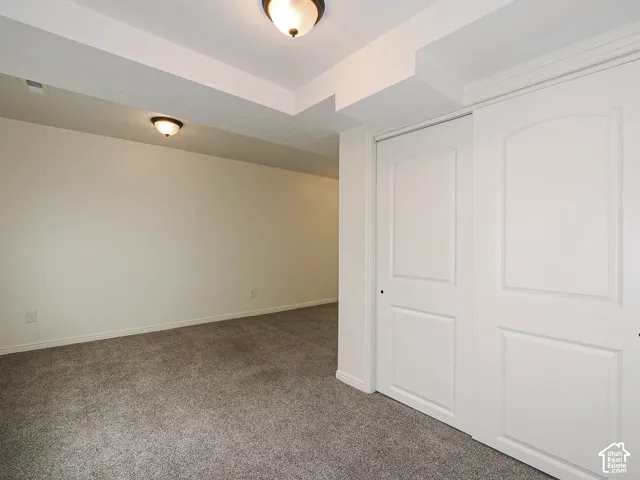 Built-in closet with panel doors, recessed lighting, neutral wall paint, and gray carpet flooring