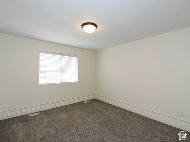Recessed window with horizontal blinds, flush mount ceiling light fixture, and plush carpeting