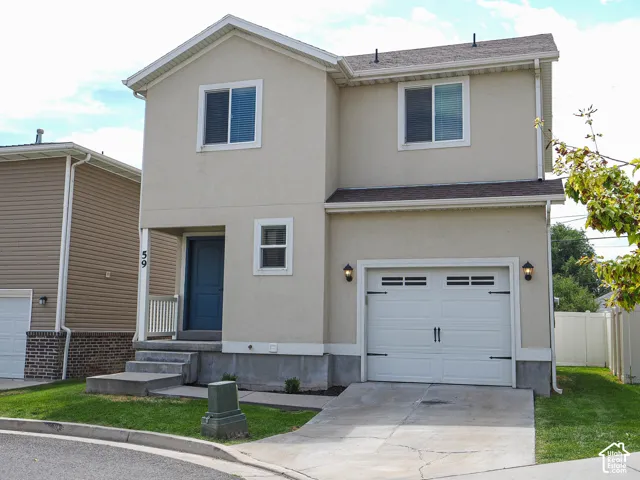 Stucco exterior with an attached garage, covered entry, and a paved driveway
