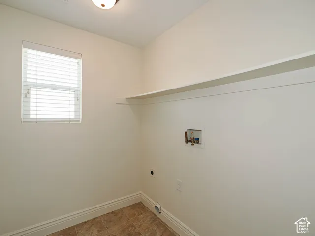 Window with blinds, wall-mounted shelving, and utility hookups