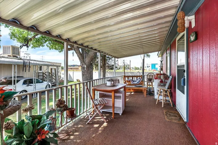 Covered porch with a textured outdoor carpet and white railings