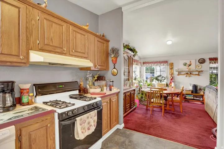 Kitchen with wood cabinetry, gray painted walls, and a built-in range