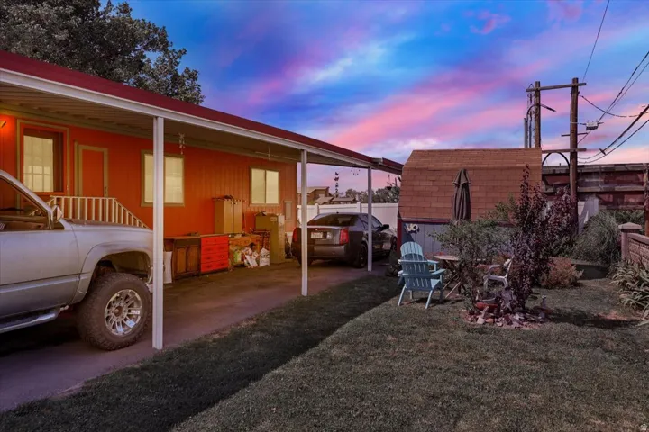 Red-sided structure with a covered carport, offering ample shaded parking