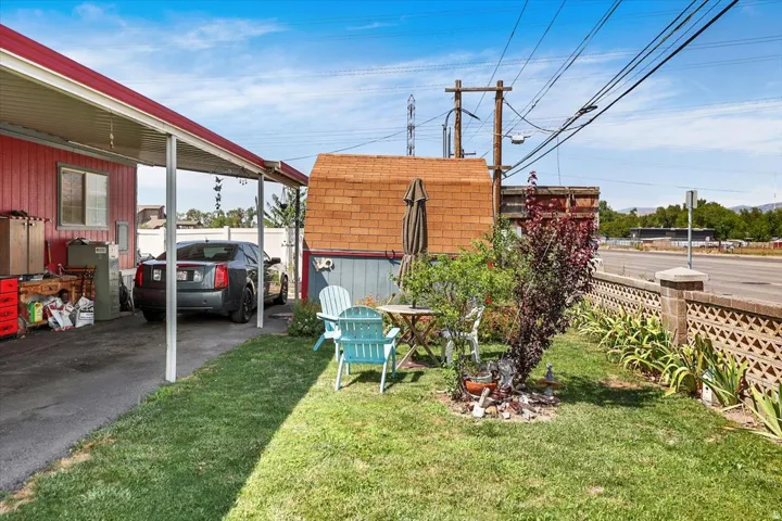 Carport parking with an adjacent lawn area and a brick-patterned decorative fence