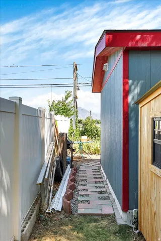 Detached structure with blue siding and a red trim roof
