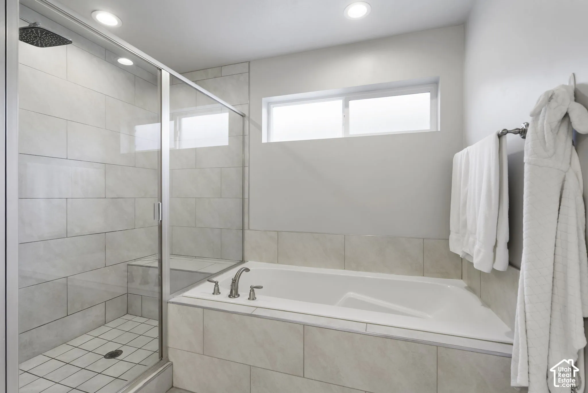 Bathroom featuring a walk-in shower with glass enclosure, rain shower head, and built-in bench