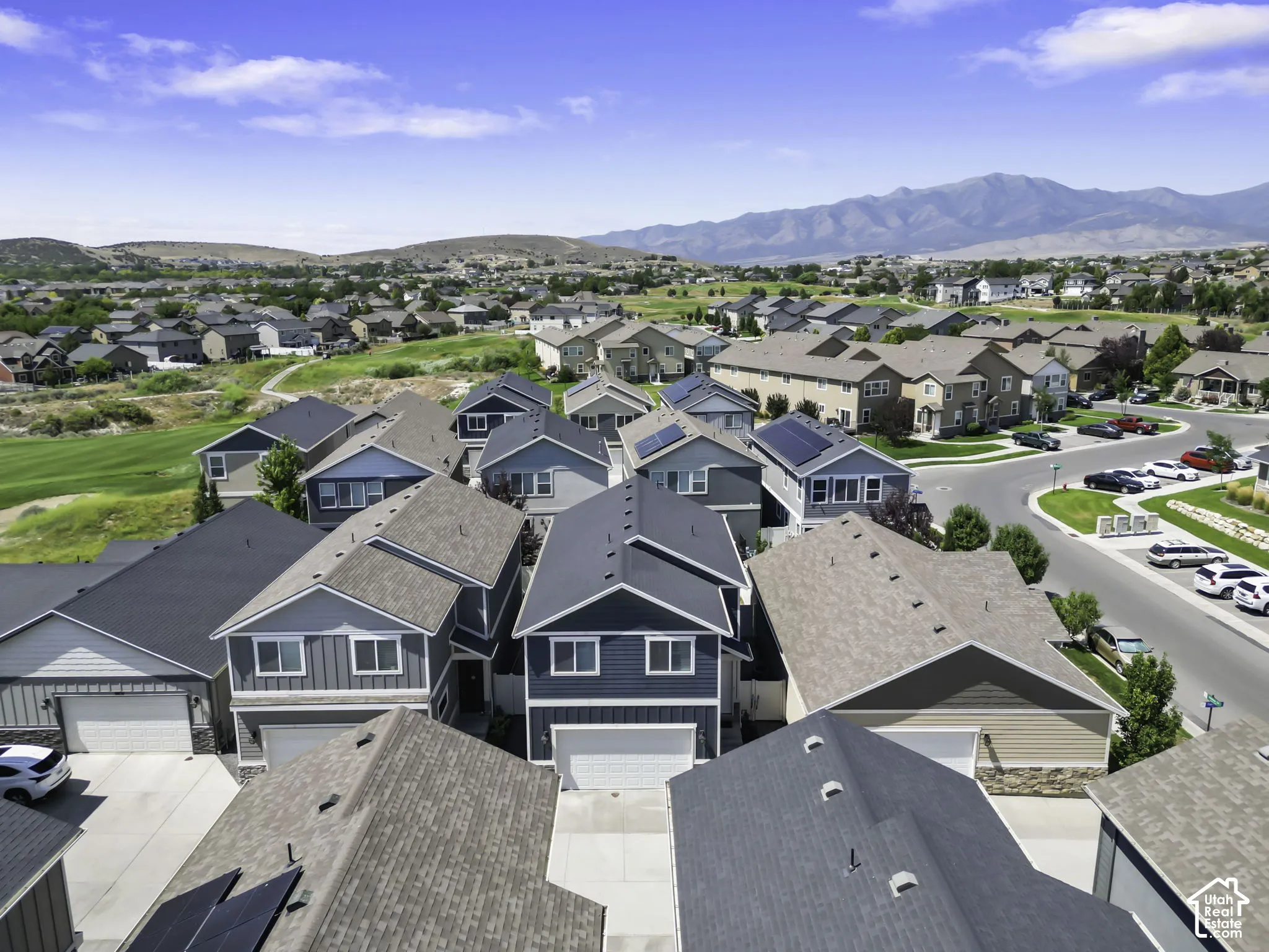 Residential development featuring a variety of home styles and rooflines, some with solar panel installations