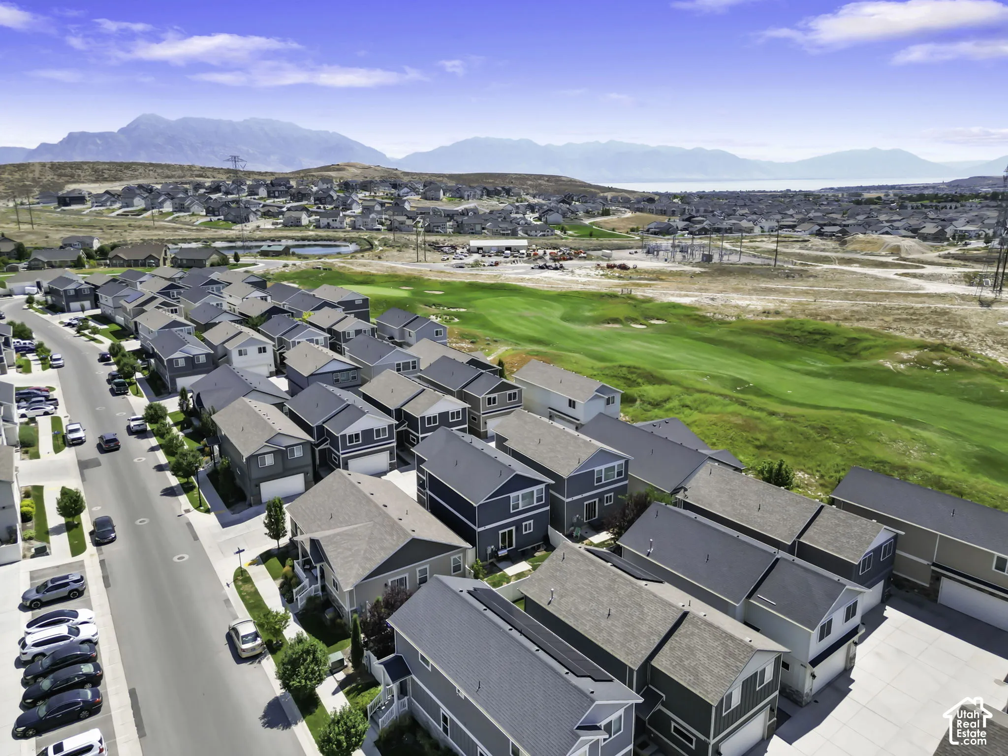Aerial perspective of a residential community featuring multiple detached homes with varying exterior finishes and rooflines