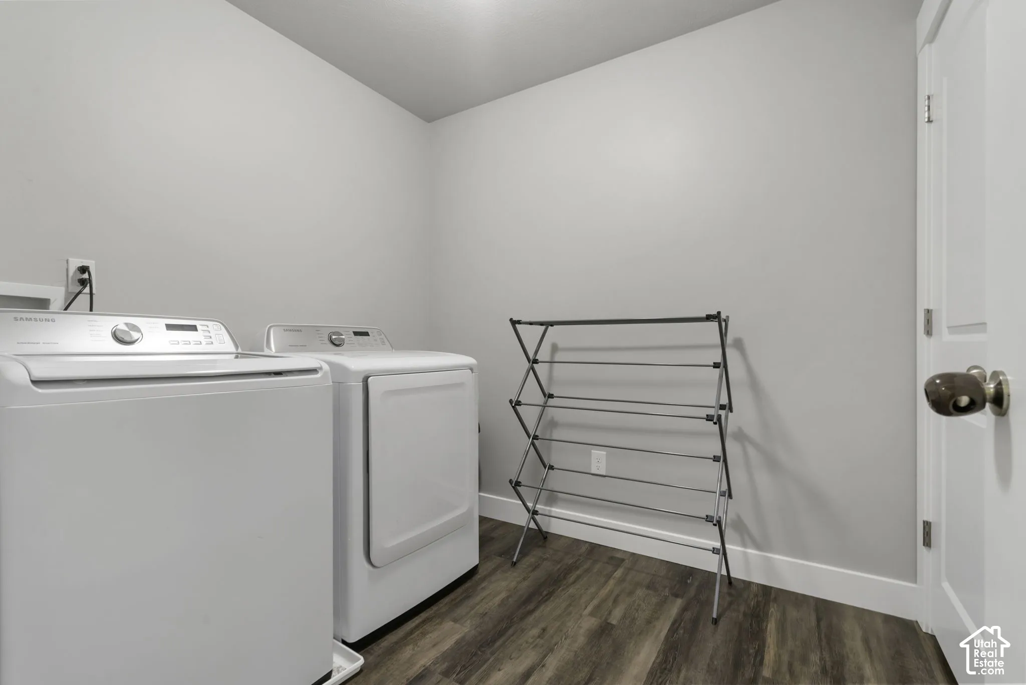 Dedicated laundry area featuring wood-finish flooring