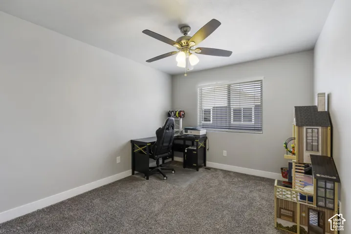 Neutral-toned room with carpet flooring, a window featuring blinds, a ceiling fan with integrated lighting, and white baseboards