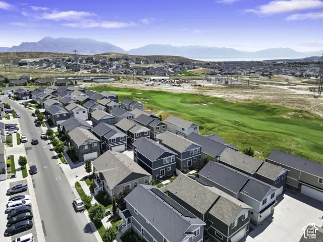 Aerial perspective of a residential community featuring multiple detached homes with varying exterior finishes and rooflines