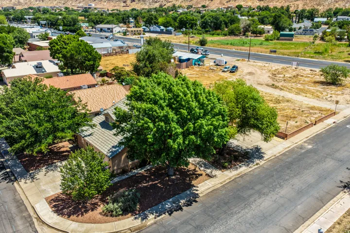 Residential property featuring mature trees and a paved driveway