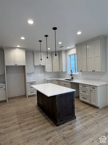 Kitchen featuring light-toned cabinetry, a dark-finish center island, stone-surface countertops, recessed lighting, and wood-finish flooring