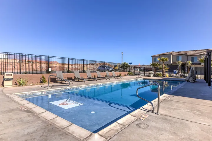 Outdoor swimming pool with concrete decking, featuring a tiled pool interior and a built-in spa