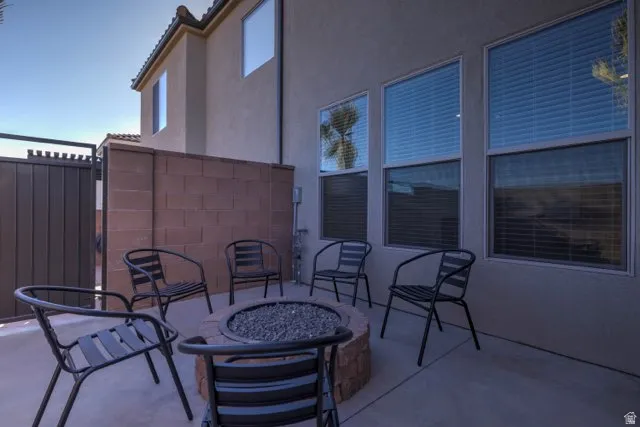 Concrete patio featuring a built-in stone fire pit