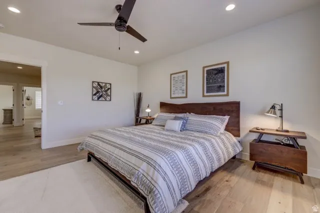 Spacious room featuring wood-finish flooring, recessed lighting, and a ceiling fan