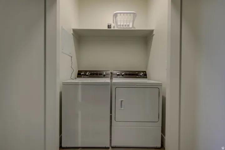 Dedicated laundry alcove featuring a top-load washing machine and front-load dryer