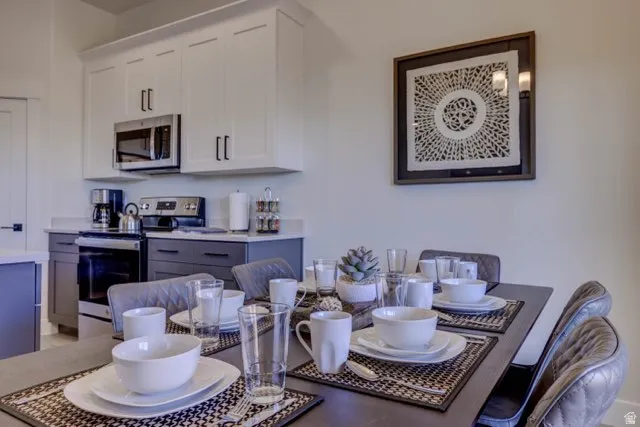 Modern kitchen featuring stainless steel appliances, two-tone cabinetry, and light-toned countertops