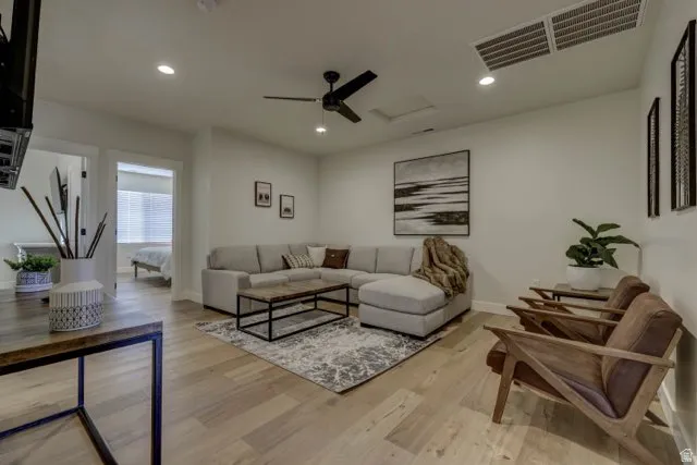 Open-concept living area featuring light wood-finish flooring, recessed lighting, and a contemporary ceiling fan