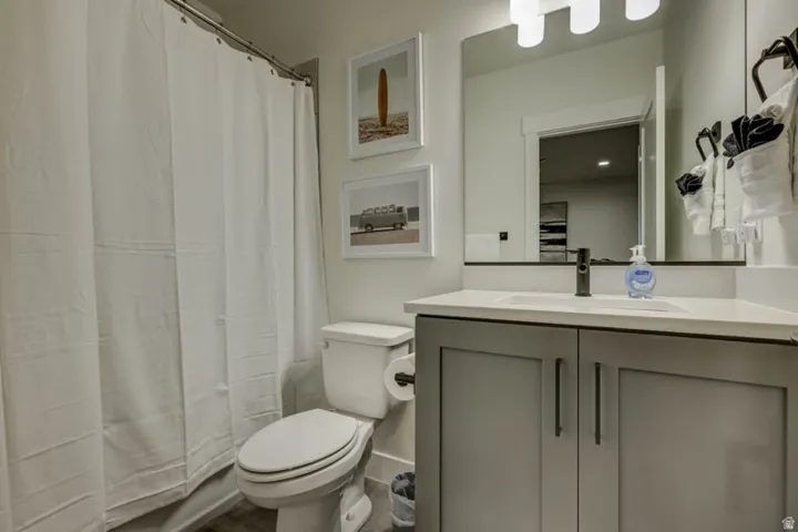 Contemporary bathroom featuring a grey vanity with a white countertop and an undermount sink
