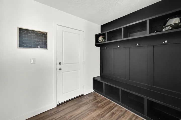 Built-in mudroom storage featuring a dark finish, open shelving, coat hooks, and integrated bench seating with cubbies