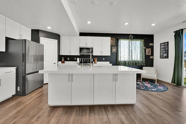 Contemporary kitchen featuring a large central island with a white countertop and base cabinetry
