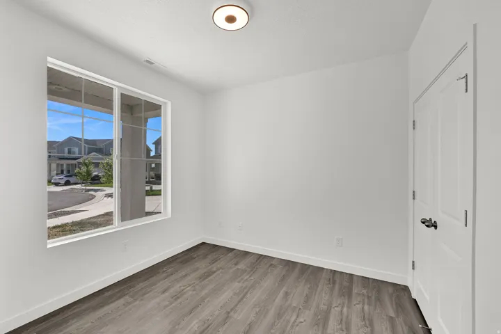 Room featuring LVP flooring, white baseboards, and a white ceiling with a flush-mount light fixture