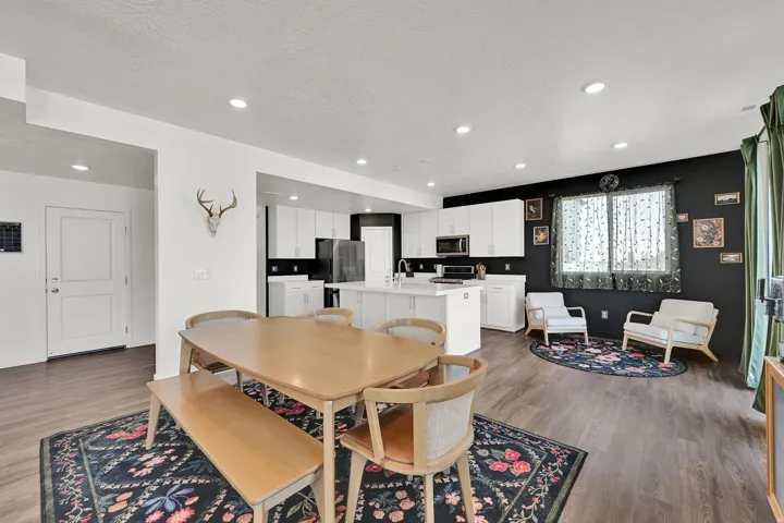 Open-concept living space featuring LVP flooring, recessed lighting, and a modern kitchen