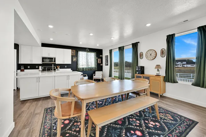 Open-concept dining area featuring LVP flooring, recessed lighting, and expansive windows