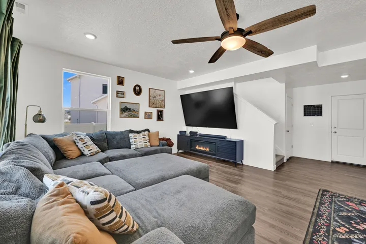 Spacious living area featuring LVP flooring, recessed lighting, and a modern ceiling fan