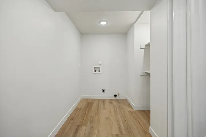 Utility room featuring wood-finish flooring, recessed lighting, and a built-in shelving unit
