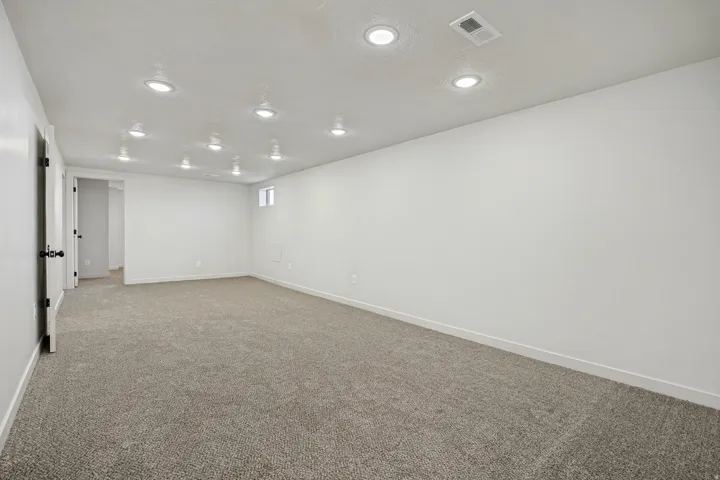 Spacious room featuring neutral carpeting and white walls