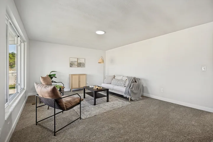 Spacious room featuring light gray carpeting and white walls