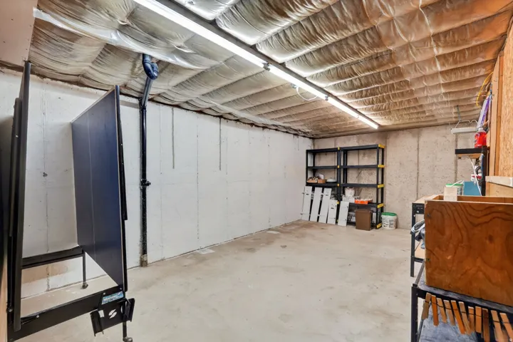 Spacious utility room featuring concrete walls, concrete flooring, and insulated ceiling