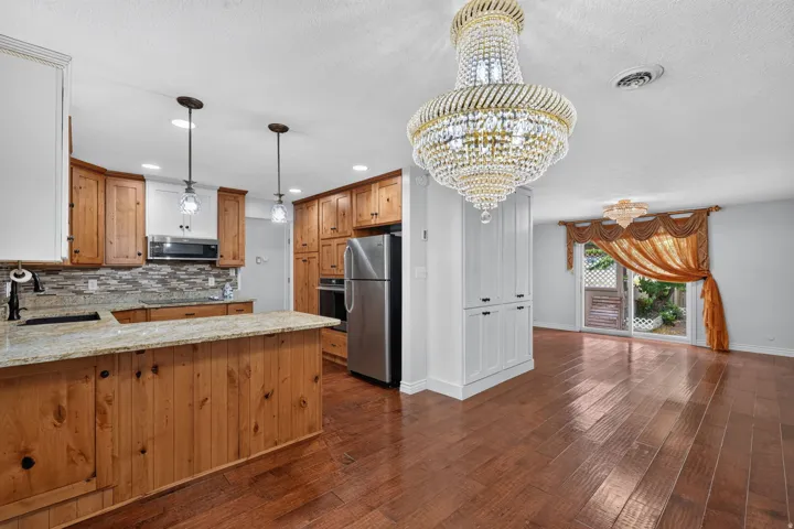 Open-concept kitchen and living area featuring wood-finish flooring