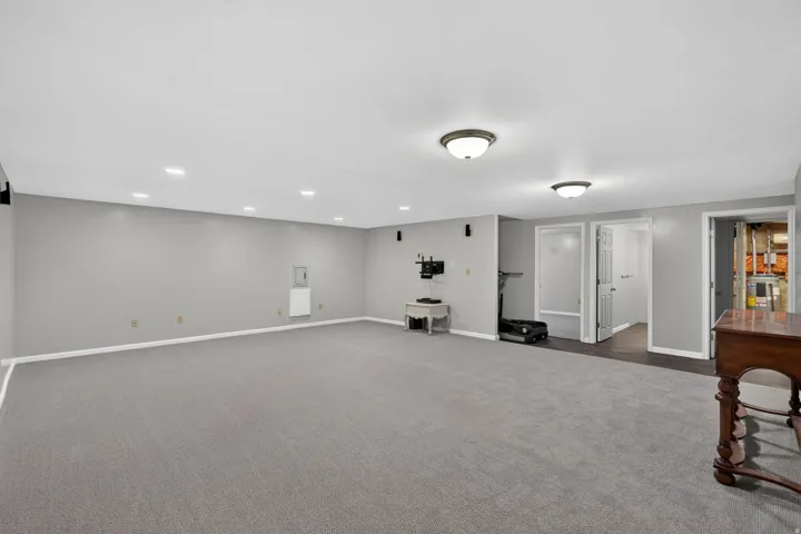 Spacious carpeted room featuring recessed lighting and two flush-mount ceiling fixtures