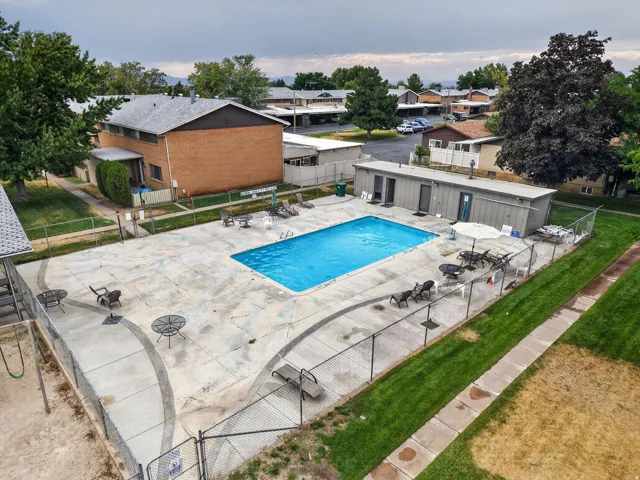 Swimming pool with surrounding concrete patio and perimeter fencing
