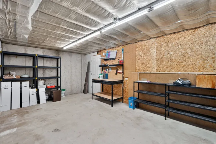 Unfinished basement space with concrete flooring, exposed concrete walls, and insulated ceiling