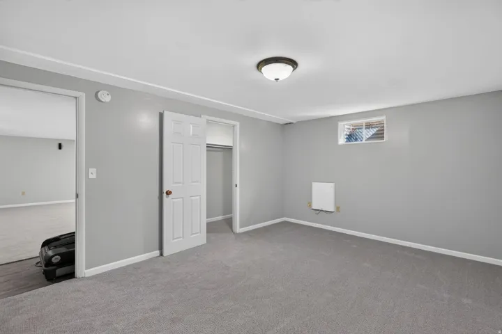 Room featuring light gray walls, gray carpeting, and white trim