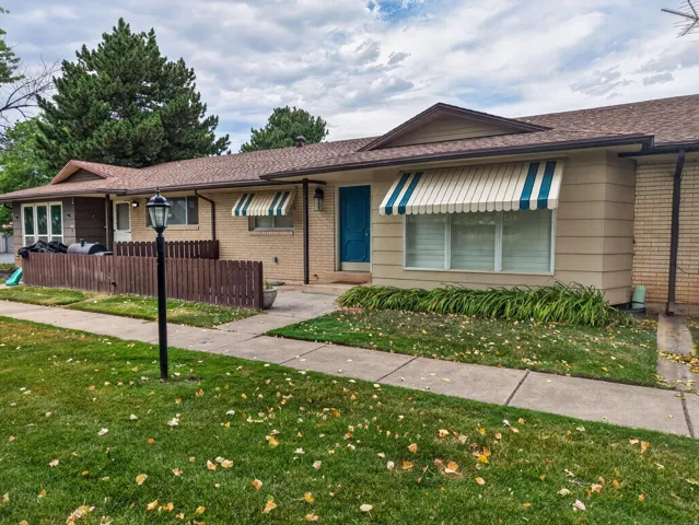 Exterior with a prominent blue entry door and striped awnings