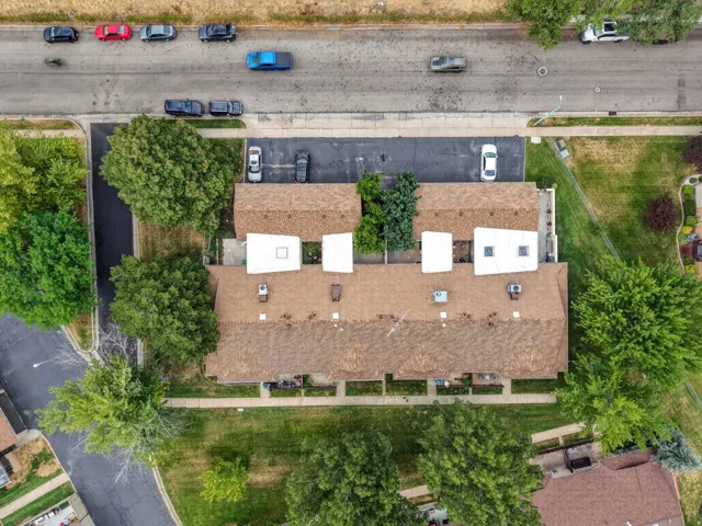 Townhome complex featuring multiple units with brown shingle roofs, individual skylights, and dedicated parking areas