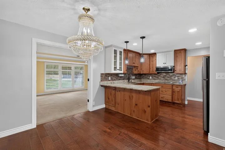 Kitchen featuring two-tone cabinetry, stone countertops, and a tile backsplash