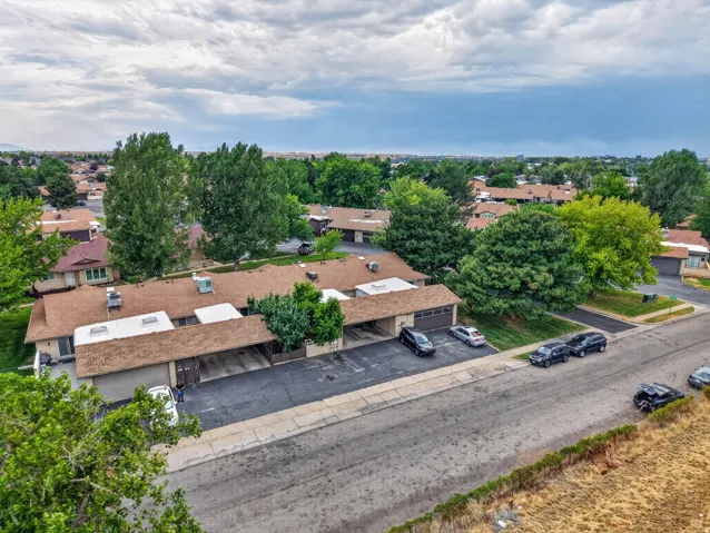 Residential community featuring asphalt streets, mature trees, and detached single-car garages