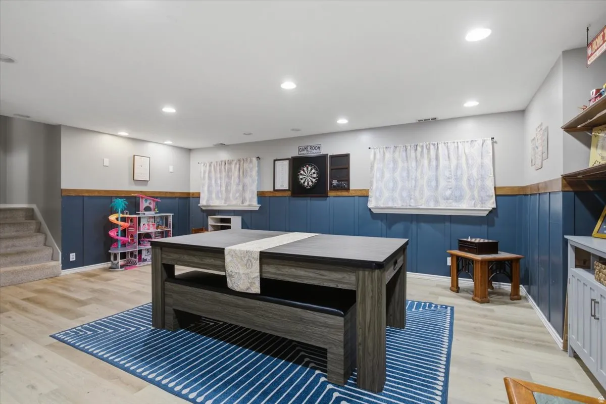 Spacious finished room featuring recessed lighting and wood-finish flooring