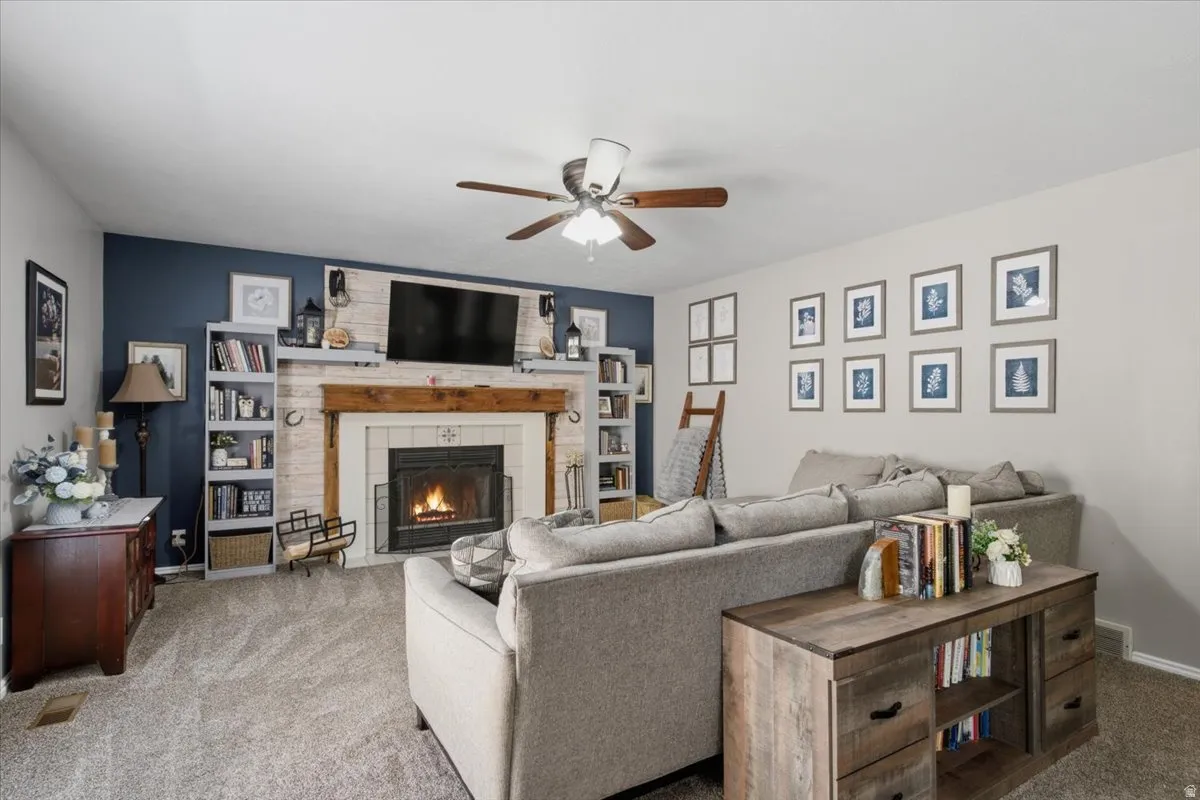 Living area featuring a central fireplace with a rustic wood mantel and tile surround
