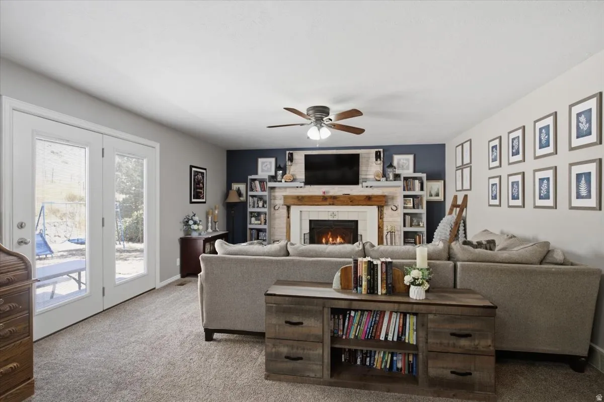 Living area featuring a textured gray carpet and light gray walls, built in's around fireplace. Mountain views from door.