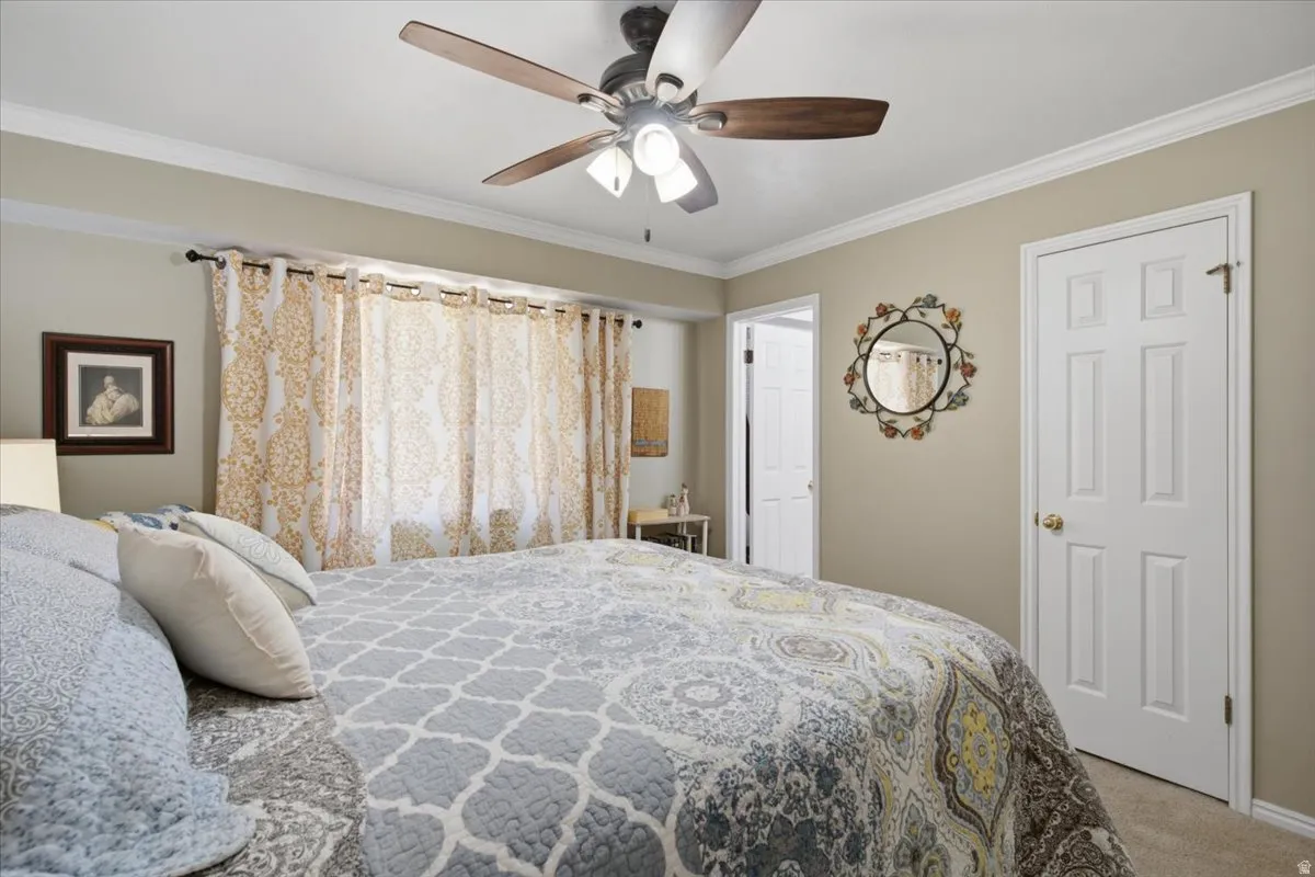 Bedroom featuring a ceiling fan with light fixture, crown molding, an oversized closet and en-suite bath. Mountain views from this room.