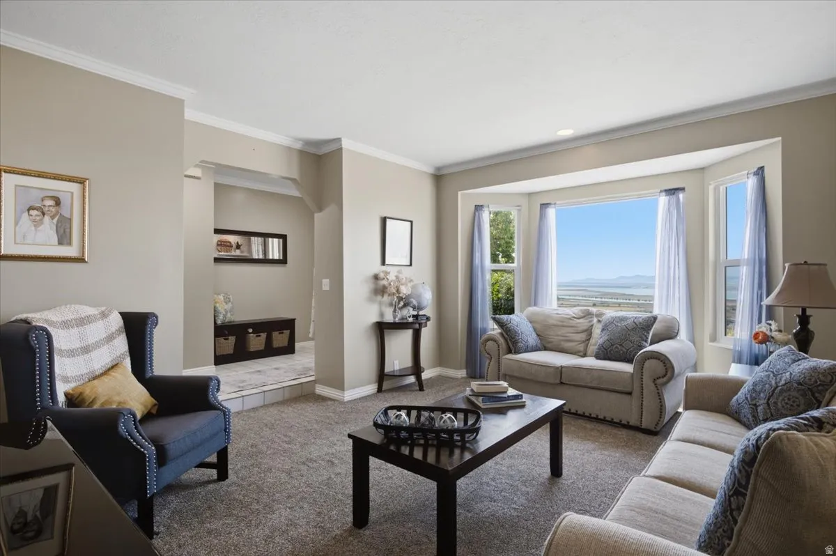 Living area featuring a spacious bay window with scenic valley and lake views, neutral wall tones, crown molding, and recessed lighting. Valley and lake views.