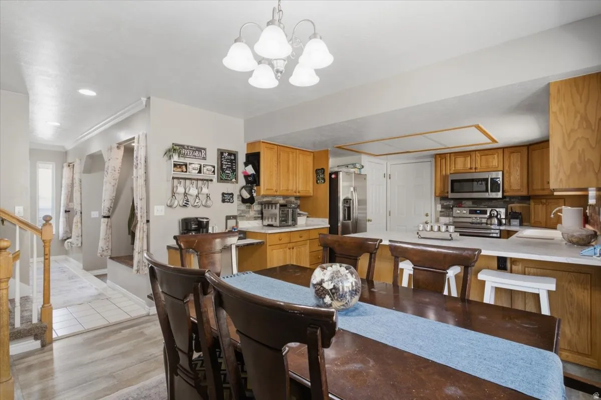 Dining area with a chandelier and wood-finish flooring