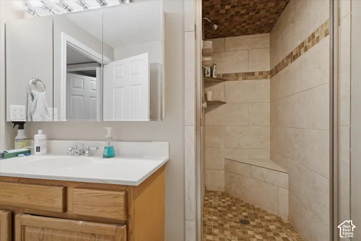 Walk-in shower with full wall tiling, textured ceiling and floor tiling, and a built-in bench